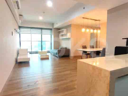 Open-concept living room with a dining area and kitchen, featuring hardwood floors and modern lighting.