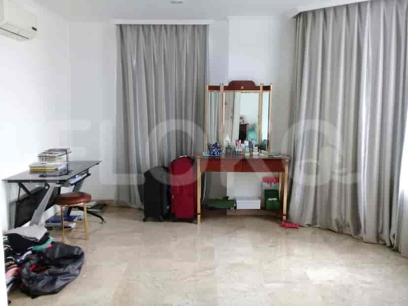 A bedroom with a vanity, curtains, and luggage.