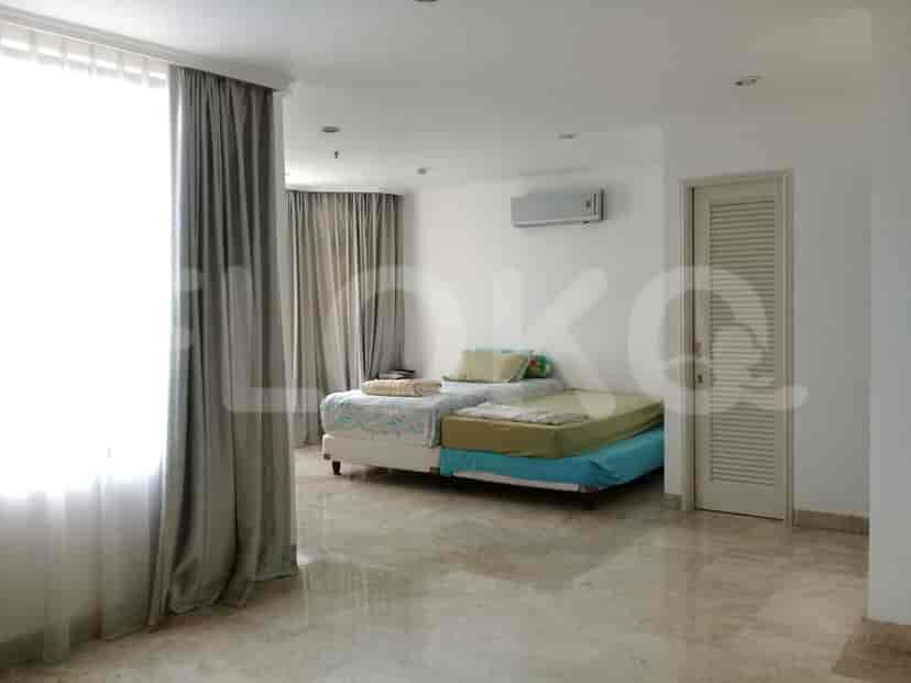 A bedroom with two beds and curtains.