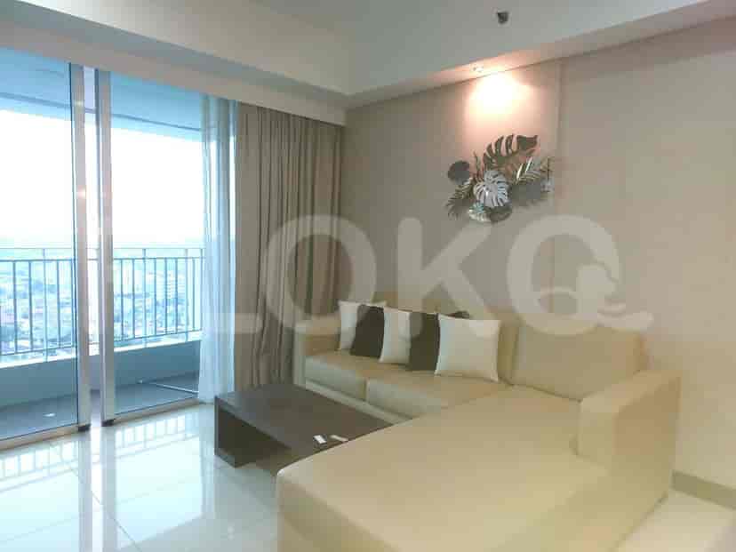 Living room with a beige L-shaped sofa, a coffee table, and a balcony.