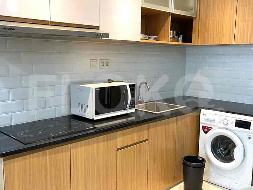Modern kitchen with wooden cabinets, a microwave, and an electric stove.