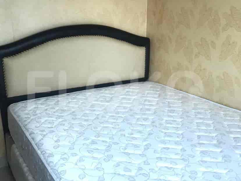 Kamar tidur dengan tempat tidur yang menampilkan sandaran kepala hitam.