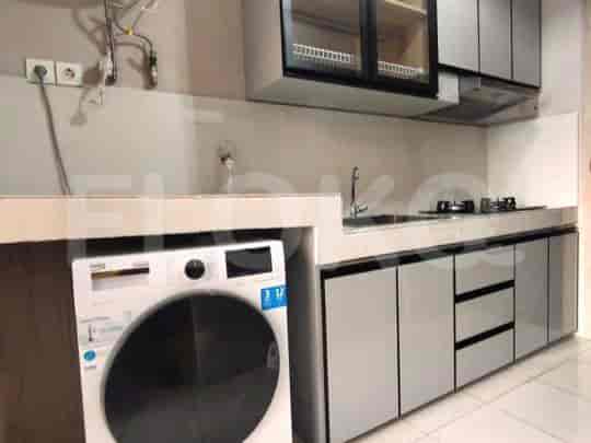 Modern kitchen with a washing machine and stainless steel appliances.