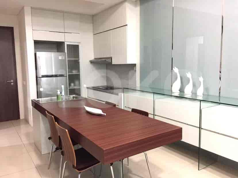 Modern kitchen with a dark wood counter, refrigerator, and cabinets.