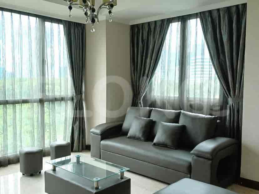 Living room with a grey sofa, glass coffee table, and large windows.