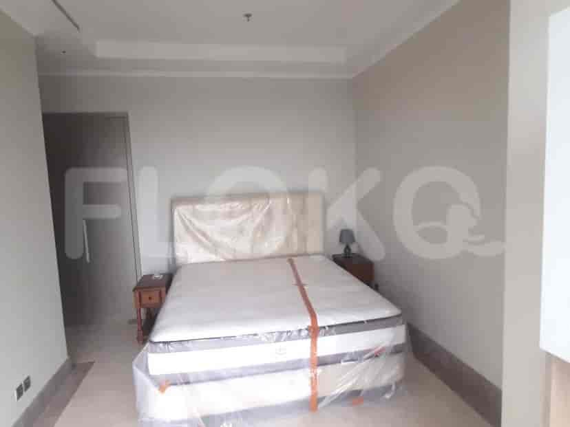 A bedroom with a bed wrapped in plastic, bedside table, and a view.