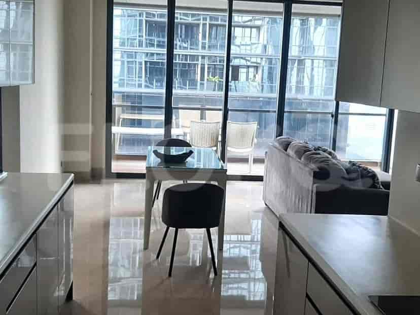 A modern kitchen and dining area with a glass table and a view of a city through large windows.