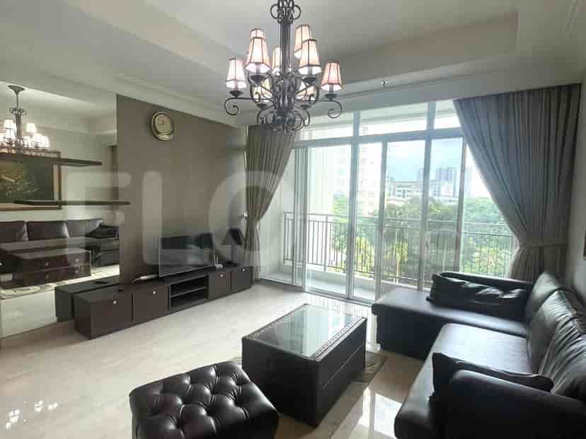 Ruang tamu yang elegan dengan sofa kulit gelap, jendela besar, dan lampu gantung.