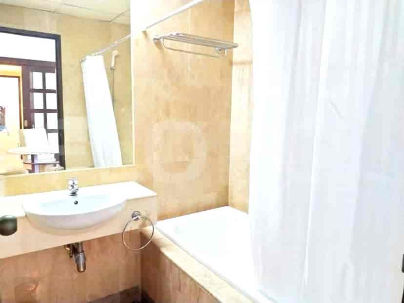 Kamar mandi dengan bak mandi, wastafel, dan cermin.