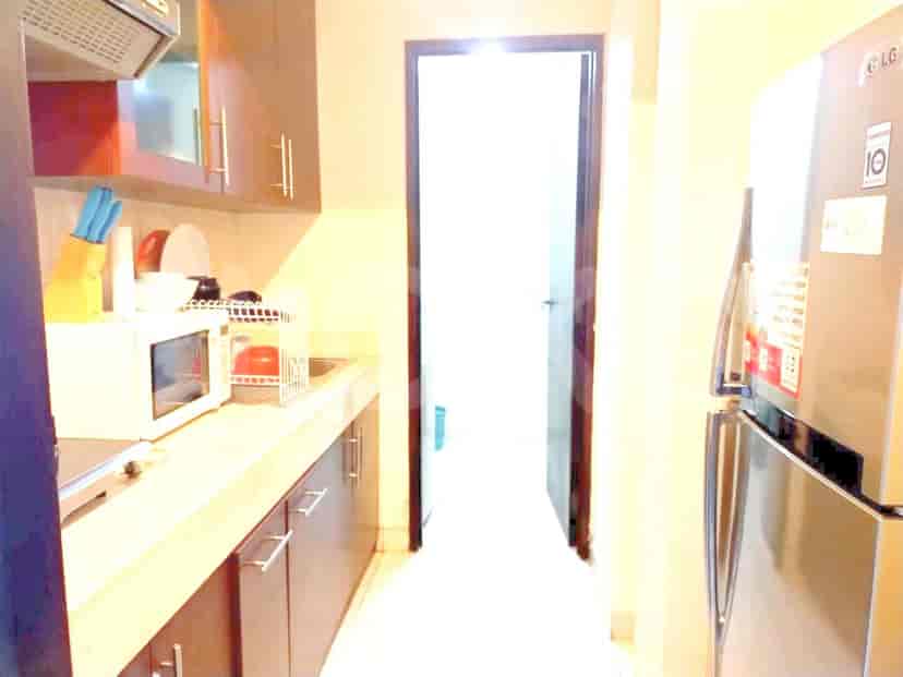 Dapur kecil dengan lemari, peralatan, dan pintu.