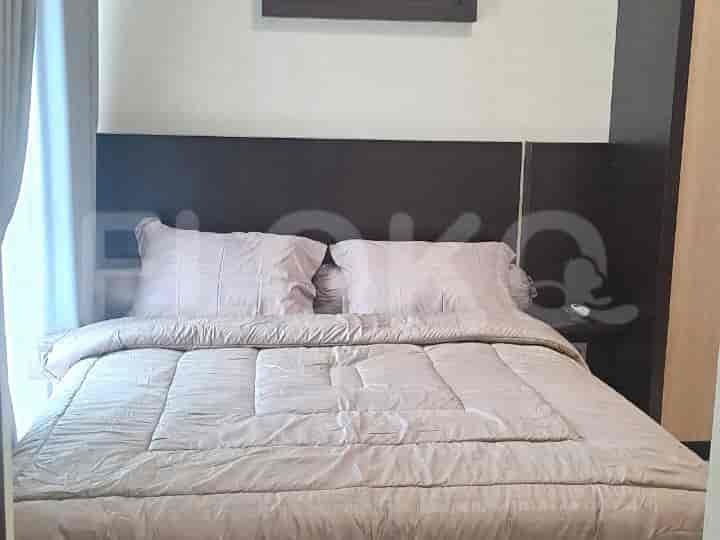 Kamar tidur dengan tempat tidur yang ditutupi dengan selimut coklat muda.