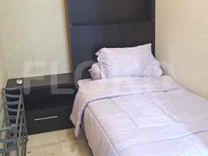 Kamar tidur kecil dengan tempat tidur single dan meja samping tempat tidur.