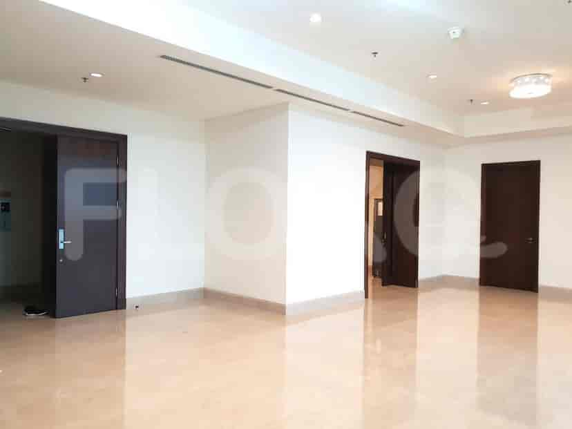 A spacious, well-lit empty room with three dark wooden doors and a marble floor.