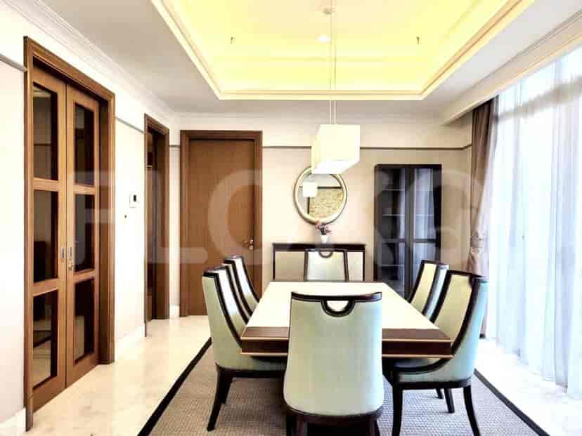 A formal dining room with a large dining table and elegant chairs.