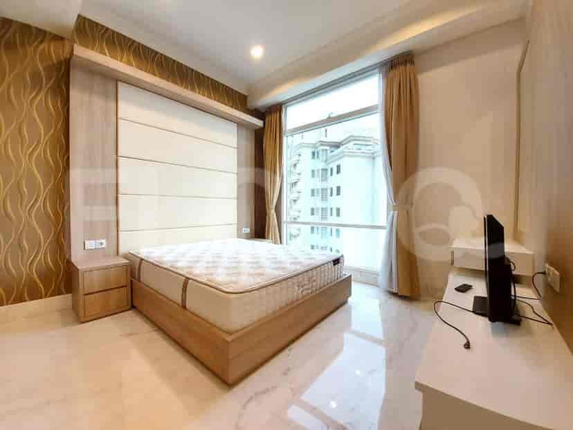 Kamar tidur dengan tempat tidur besar, meja samping tempat tidur, dan jendela dengan pemandangan.