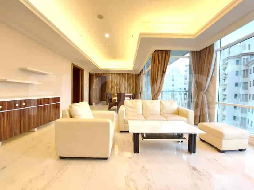Area ruang tamu dan ruang makan kontemporer dengan sofa krem, meja kopi putih, dan set ruang makan di dekat jendela besar.