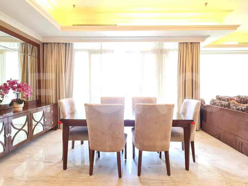 A dining area with a wooden table, chairs, and a mirrored sideboard.