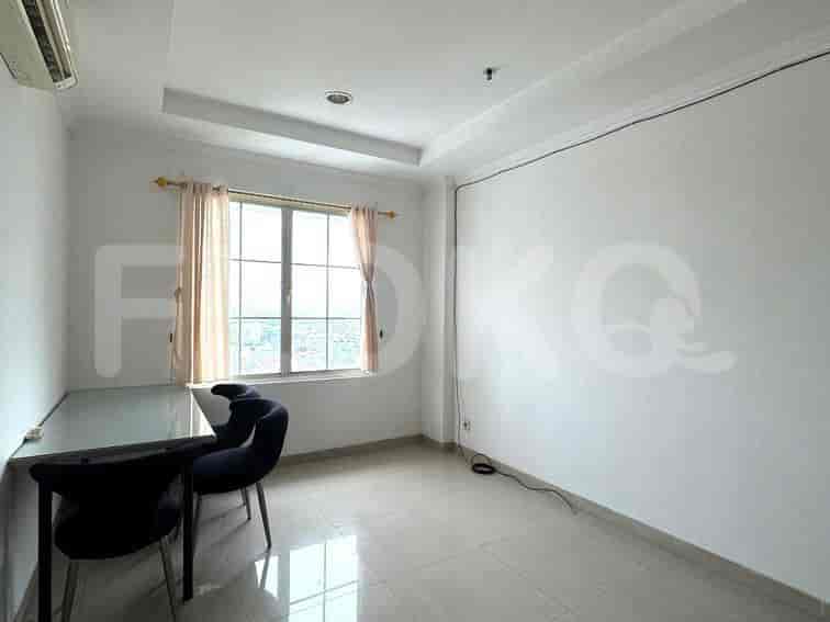 An office space with a desk, chairs, and a window.
