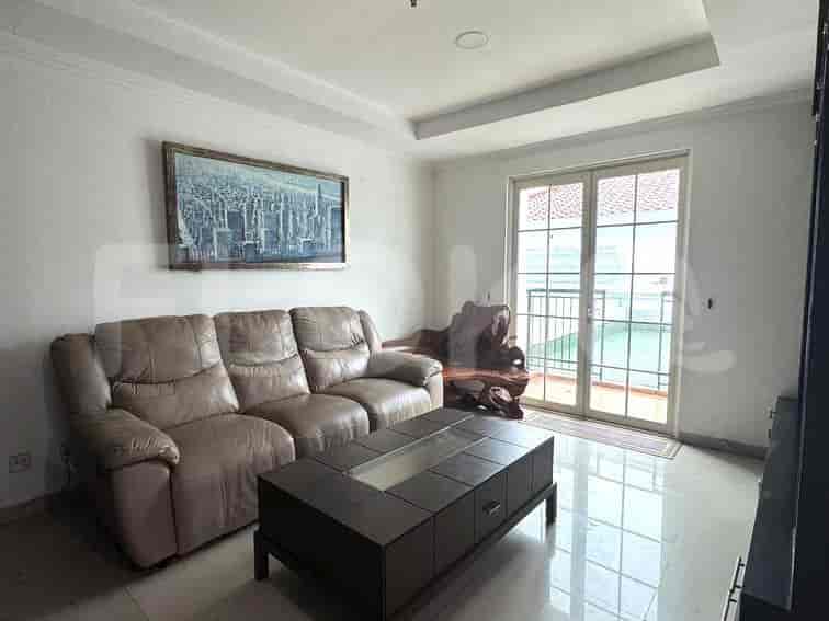 Living room with a beige leather sofa, a painting, and a coffee table.