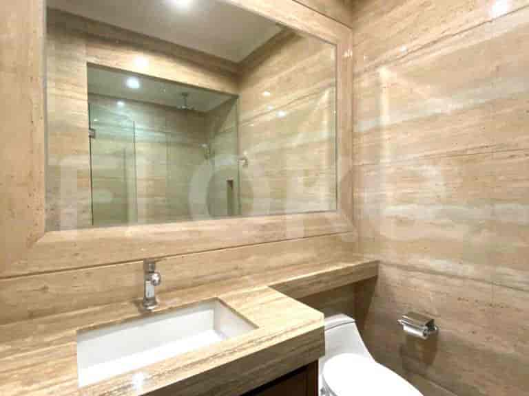 Modern bathroom featuring a large mirror, marble finishes, and a sink.