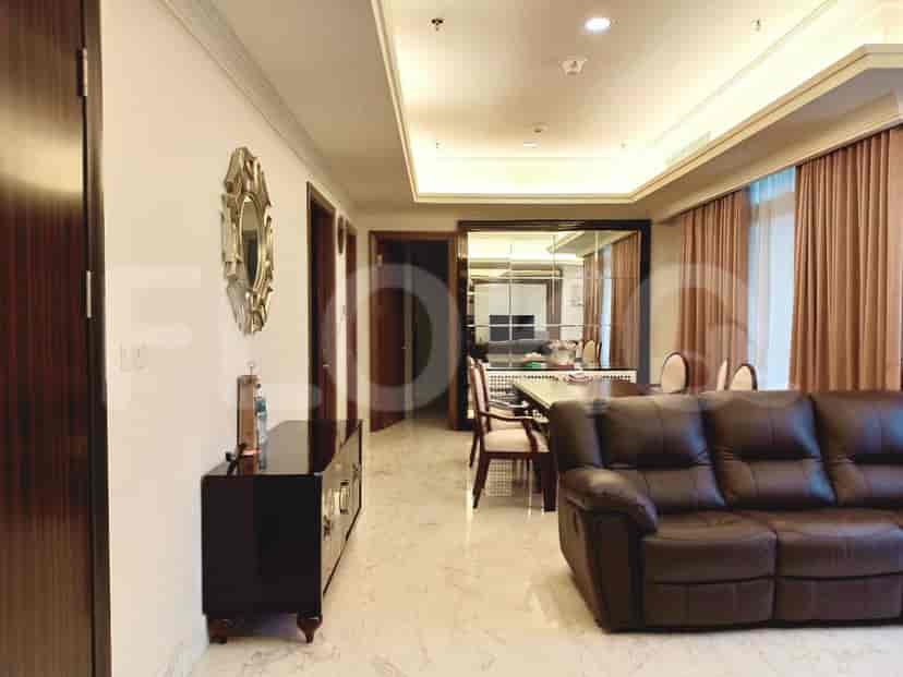 A luxurious living and dining area with marble flooring and dark wood accents.
