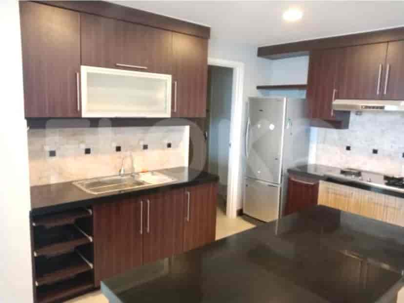 Kitchen with dark wooden cabinetry, stainless steel appliances, and a black countertop.