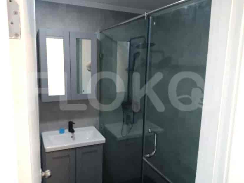 Bathroom with a grey vanity, a glass shower enclosure, and a mirror.