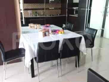 A dining area with a large table, chairs, and kitchen access.