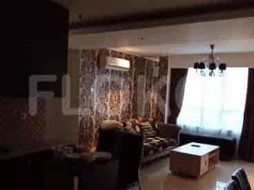 A well-lit living area with a patterned accent wall, sofa, and dining space.