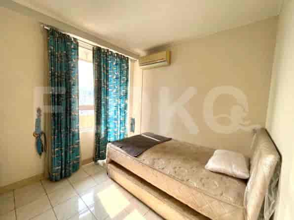 A small bedroom with a single bed and blue patterned curtains.