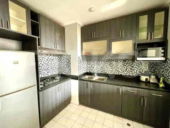 A kitchen with gray cabinets, a stove, and a refrigerator.
