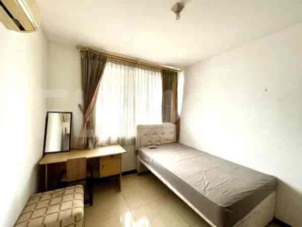 A single bedroom with a bed, desk, and mirror.