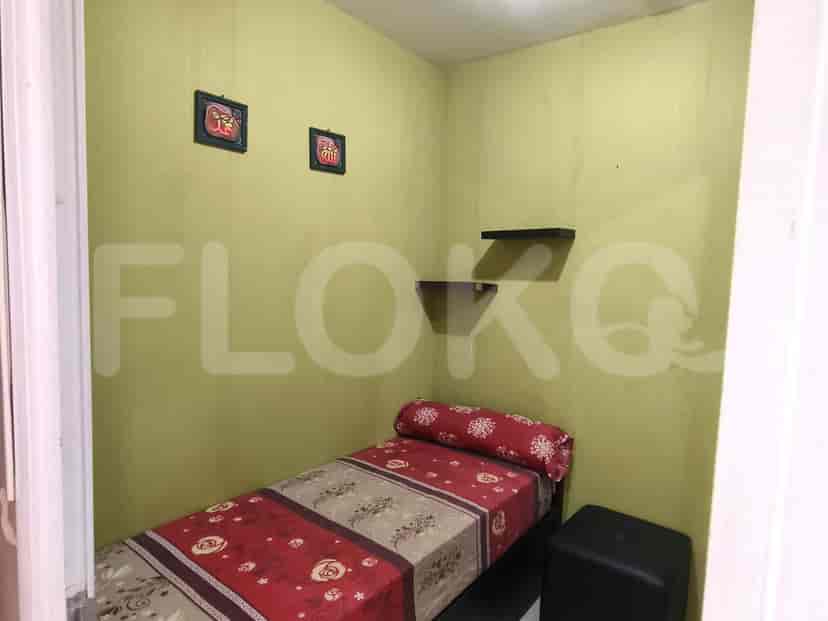 A small bedroom with bed and decorative wall art.