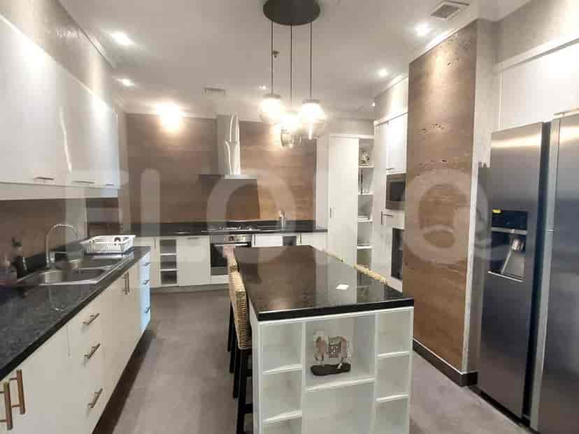 Dapur modern dengan pulau, lemari putih, dan peralatan stainless steel.