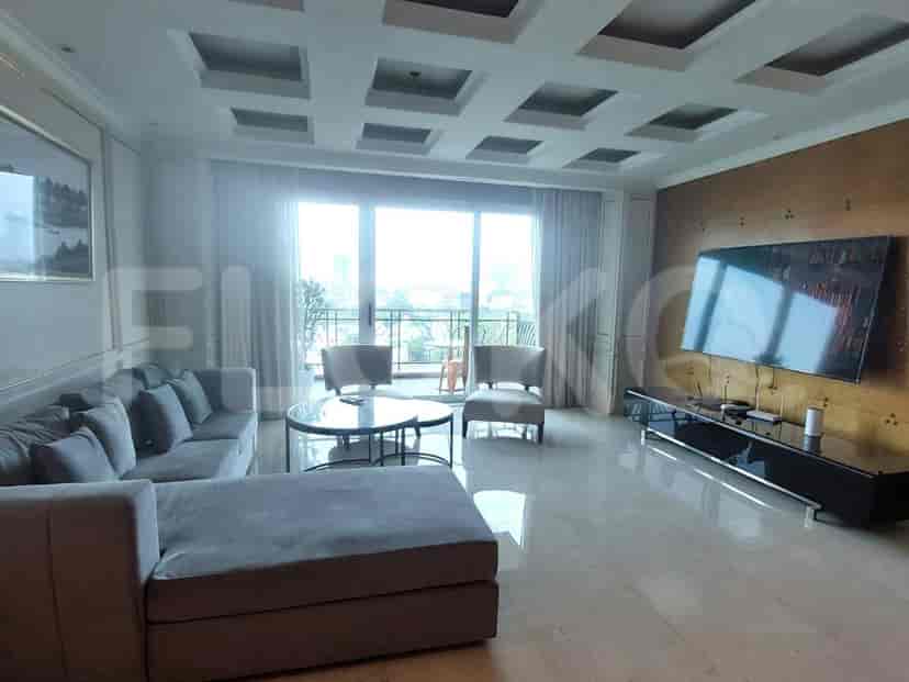 Ruang tamu modern dengan sofa abu-abu, TV, dan pemandangan balkon.