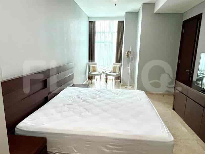 Kamar tidur yang menampilkan tempat tidur, meja samping, dan jendela.