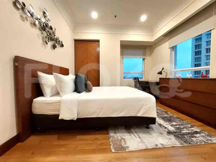 Another bedroom with a king bed, wooden floor, and city view.