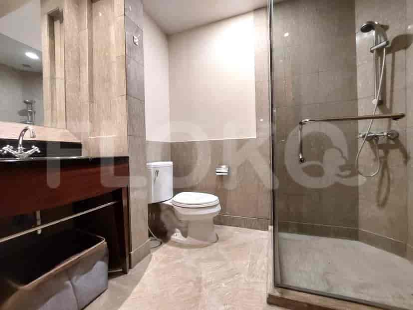 A modern bathroom with a walk-in shower and neutral tile.