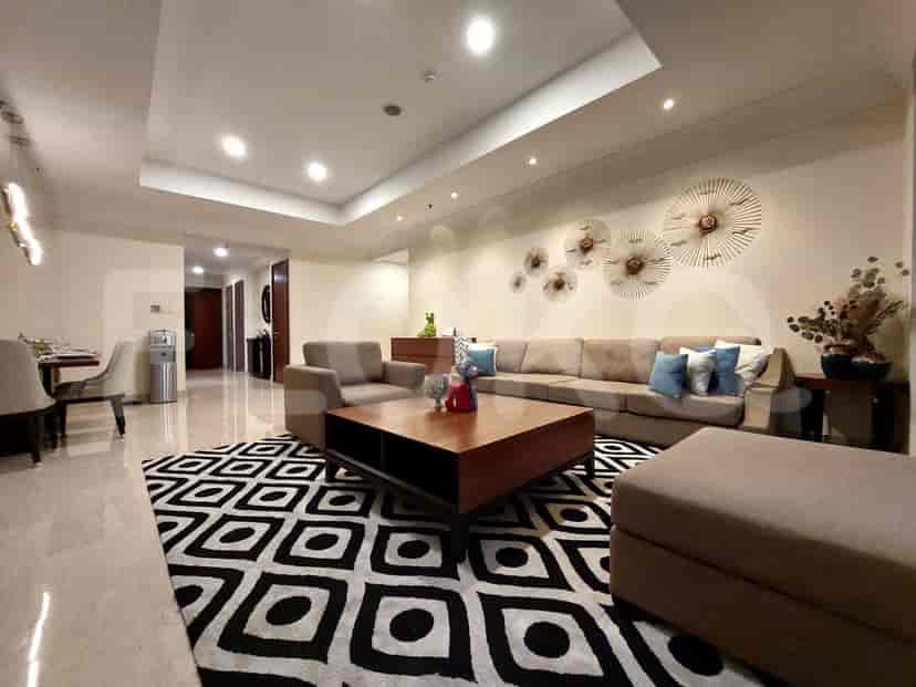A modern living room with a large sofa, patterned rug, and decorative wall art.