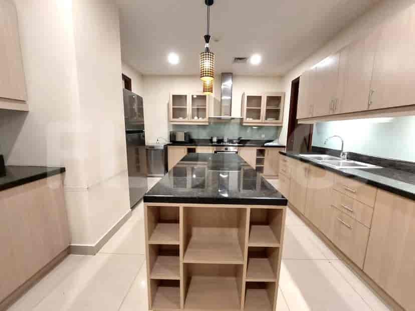 A modern kitchen with an island, stainless steel appliances, and light wood cabinets.