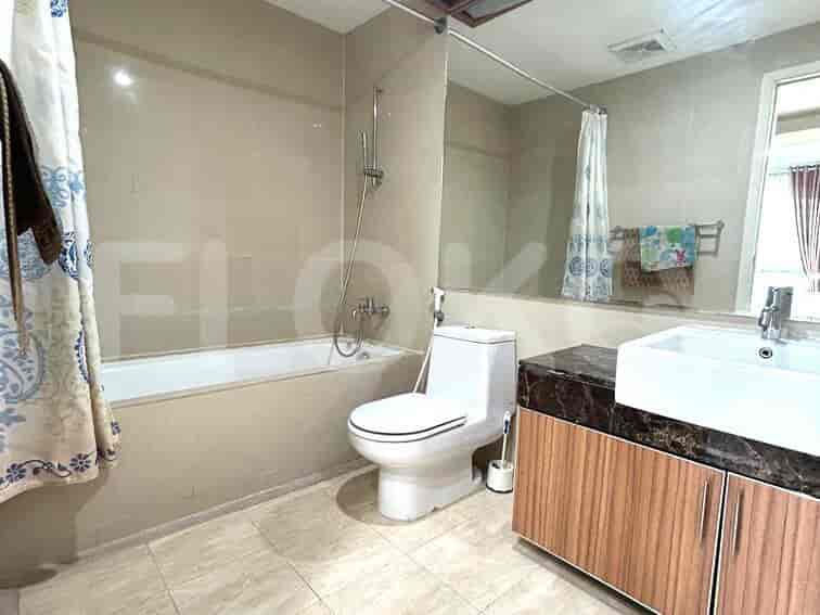 A modern bathroom with a bathtub, toilet, and vanity with marble countertop.