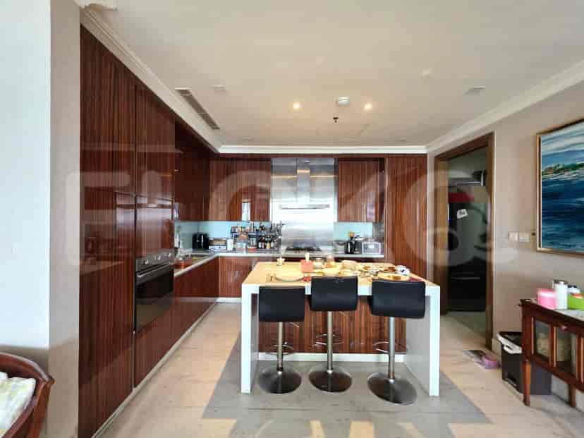 Modern kitchen with a white island and wooden cabinets.