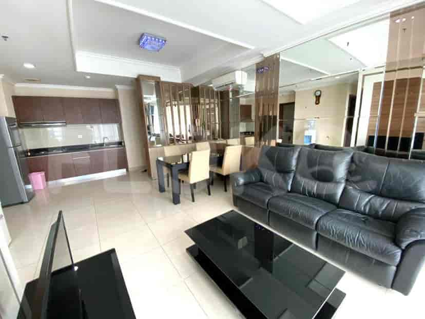 Open-plan kitchen with a dining area and black leather sofa.