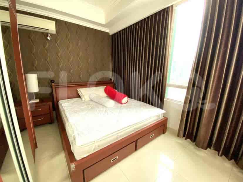 Cozy bedroom with a wooden bed, wallpapered wall, and curtains.