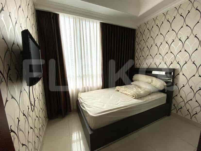 Bedroom with a TV, patterned wallpaper, and a comfortable bed.