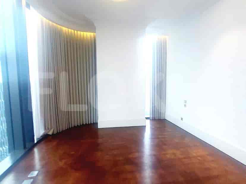 A bedroom featuring wooden flooring, curved wall, and curtains.