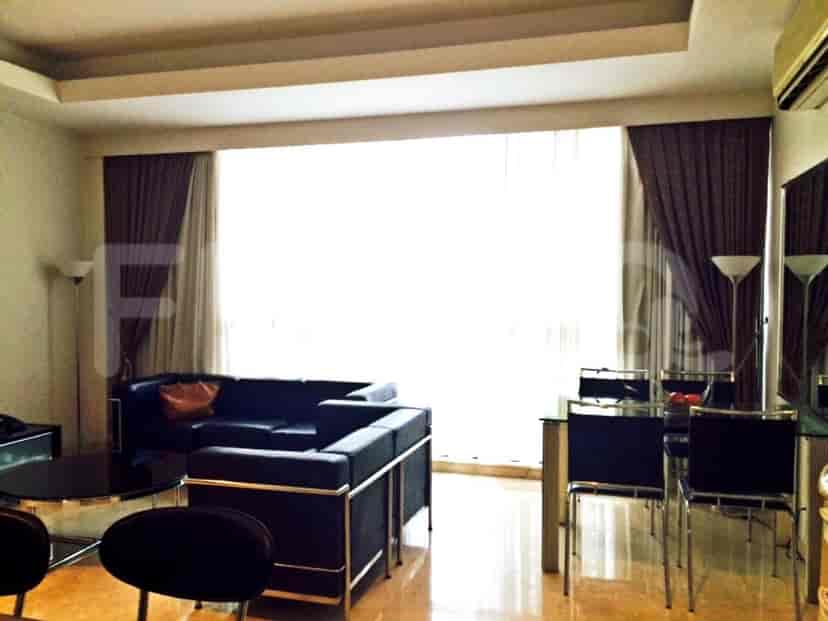 Living room with dark sofa, curtains, and a dining set.