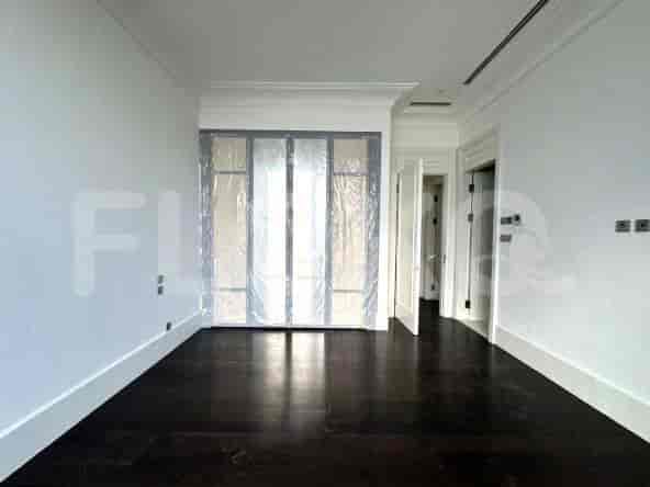 Bedroom with dark wooden floor, white walls, and a glass door.