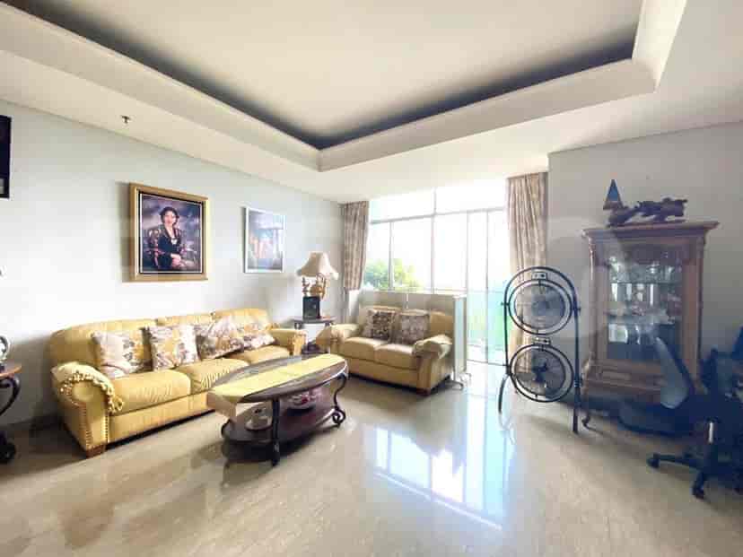 A classic living room with yellow leather sofas, a coffee table, and artwork.