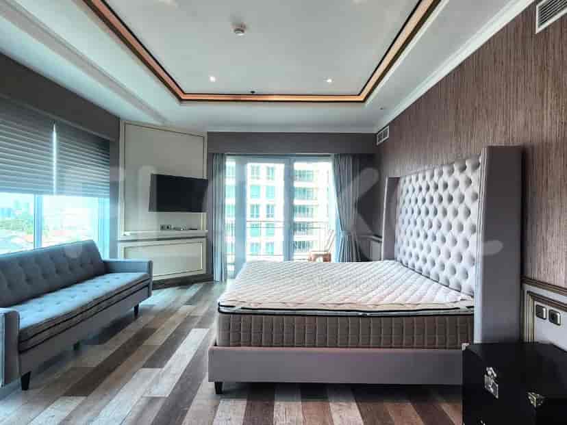 Stylish bedroom featuring a tufted bed and a neutral color scheme, complemented by wooden flooring.